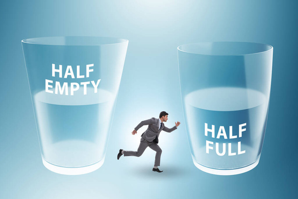 Businessman in the half empty half full glass concept - Photo, Image