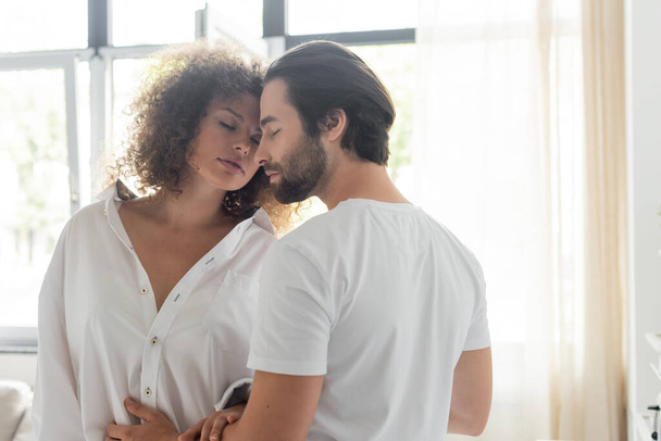 bearded man in t-shirt seducing sensual girlfriend in white shirt  - Фото, изображение