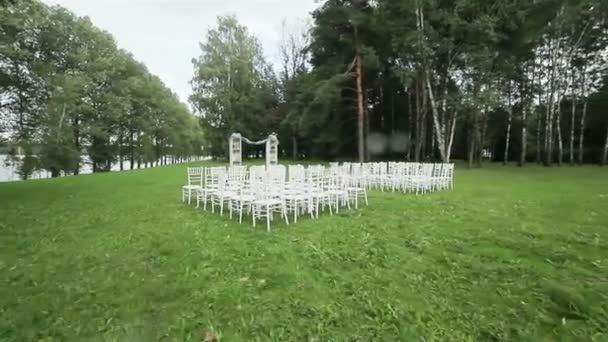 Filas de sillas en el césped listo para la ceremonia de boda al aire libre. Steadicam
 - Metraje, vídeo