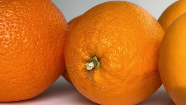 Whole orange fruits on white background. Close-up. Slow motion. - Metraje, vídeo