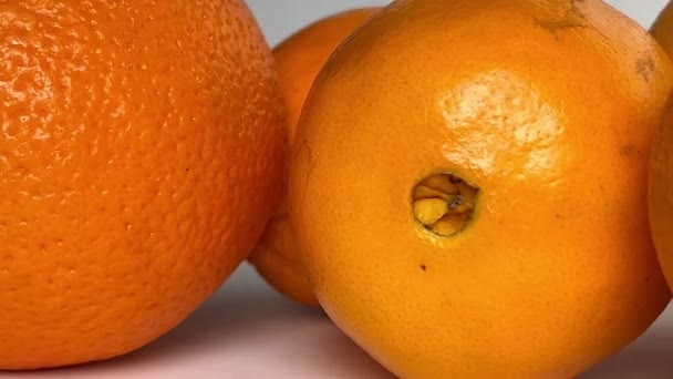 Whole orange fruits on white background. Close-up. Slow motion. - Video
