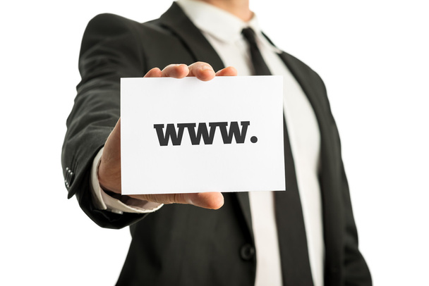 Businessman in a suit holding up a business card with www sign - Photo, Image