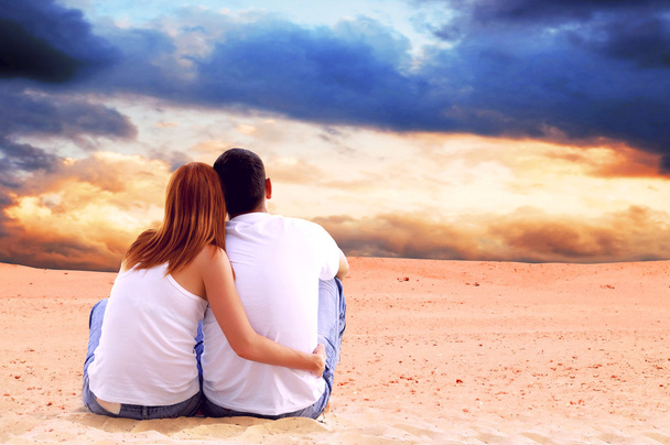 Young couple seating in desert in sunny day - Foto, Imagem