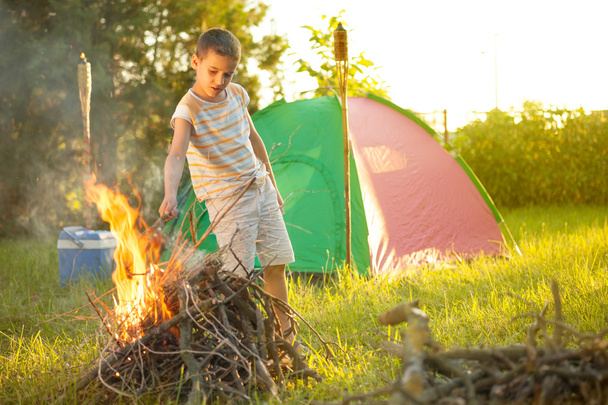 boy on a camping trip  baking sausage - Photo, image