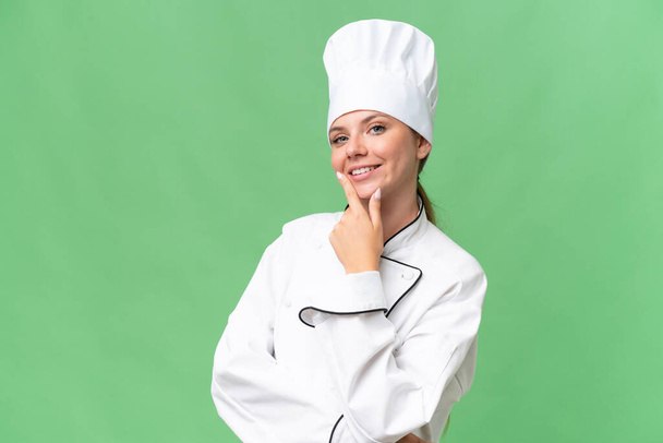 młody szef kuchni kobieta na odizolowane zielone tło  - Zdjęcie, obraz
