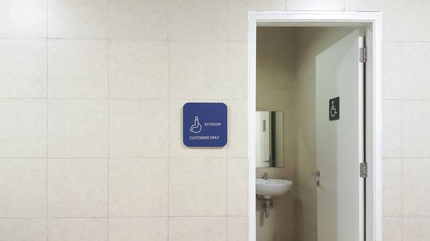 Entrance to the disabled restroom. Bathroom or water closet or WC sign for handicapped wheelchair accessible restroom. Door open. - Foto, Imagem