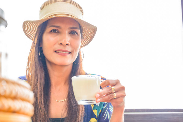 A woman traveler holding coffee cup at Chiang Saen district, Chiang Rai Province. - Φωτογραφία, εικόνα