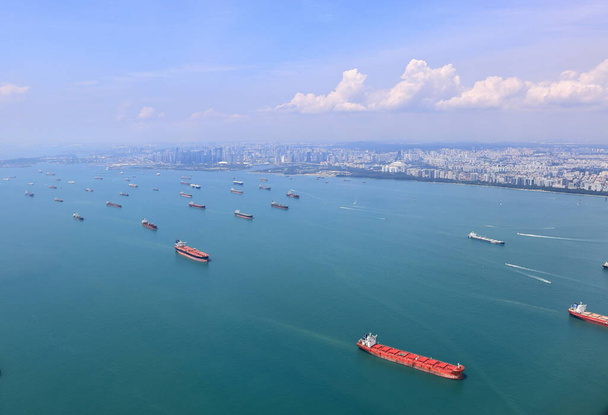 High angle shot of ocean liner, tanker and Cargo Ship in Singapore Strait and Singapore city, See from plane. - Valokuva, kuva