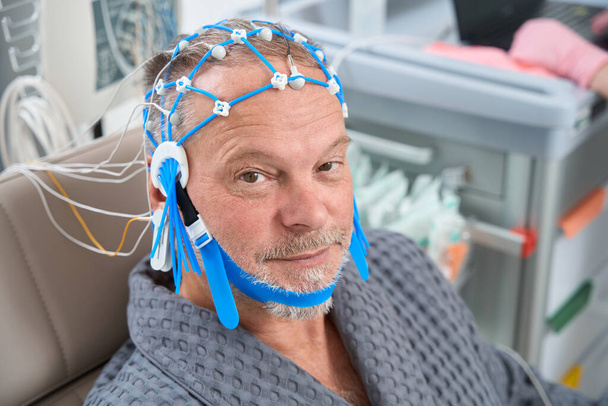 Iäkäs potilas diagnostisessa EEG-enkefalografiassa, hänelle tehdään lääkärintarkastus terveyskeskuksessa - Valokuva, kuva