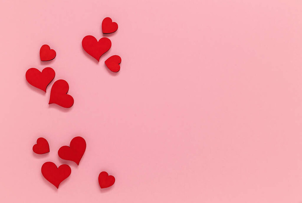 Red wooden hearts on a pink background. Valentine Day concept. Top view. Copy space. - Foto, Bild