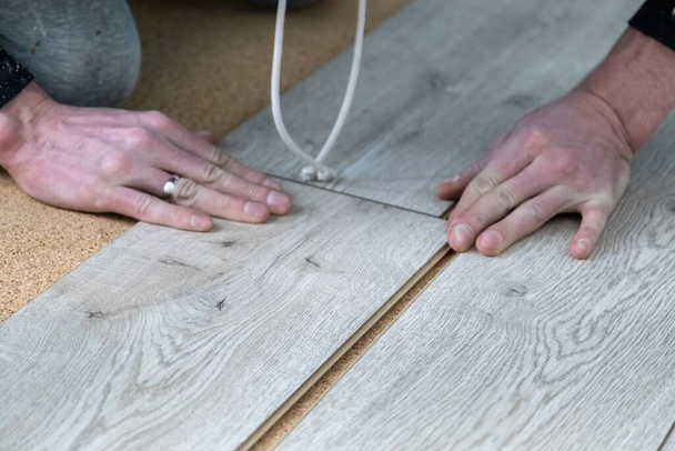 A man lays a laminate floor. Repair in the apartment. Laminate floor professionally installed - Φωτογραφία, εικόνα