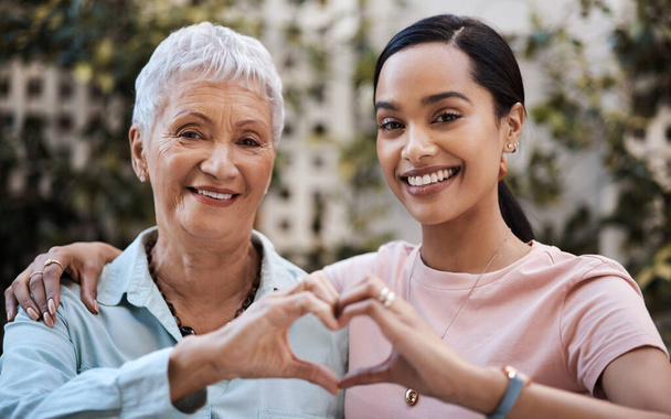 My moms got all of my heart. a senior woman and her daughter making a heart shape with their hands in the garden at home - Zdjęcie, obraz