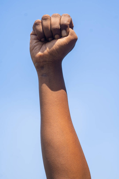 vertical shot of Concept of black history month celebration or activist Hand rising against sky during march showing with copy space. - Foto, afbeelding