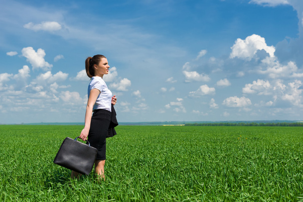 meisje in pak lopen op een veld - Foto, afbeelding
