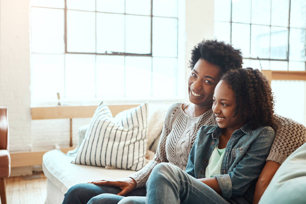 Love, mother and teen girl on sofa for happy family time together in apartment in South Africa on weekend. Smile trust and support, black woman and teenager sitting on couch with healthy relationship. - Foto, imagen