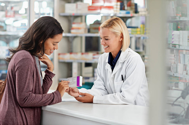 Happy, customer and pharmacist with healthcare medicine assistance, help and expertise at store counter. Advice and opinion of worker helping girl with medication information at pharmacy - Foto, imagen