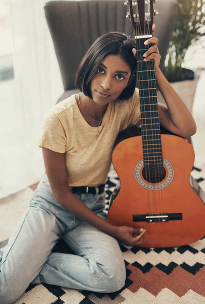 Cant get to that concert Ill make my own. Portrait of a young woman playing the guitar at home - Photo, Image