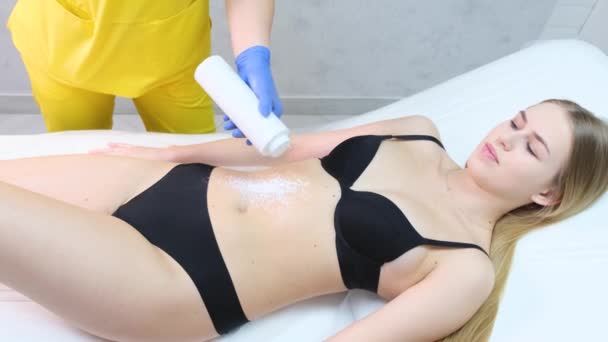 Beauty salon for removing hair from a womans body. A beautician works with a female client. Painless removal of hair from the human body - Video, Çekim