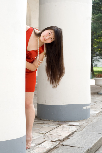 Pretty girl hiding between columns - Photo, Image