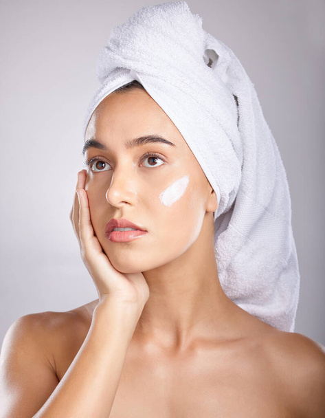Woman, head towel and cream for cosmetics, makeup and face detox on grey studio background. Young female, lady and organic facial for treatment, clear and healthy skin for natural beauty and skincare. - Φωτογραφία, εικόνα