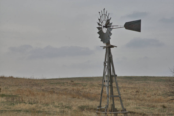 Windmills pumping water in the Nebraska Landscape alongside barns and sometimes out in pastures - Fotó, kép