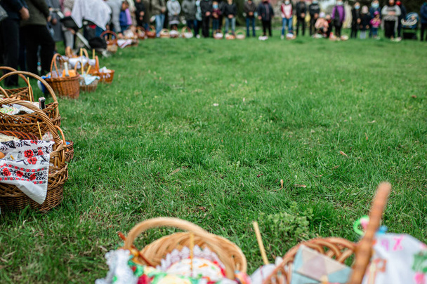 Seurakuntalaiset kirkon jumalanpalveluksessa päivänä oikeiston pääsiäisen kanssa koreja ruokaa ennakoiden vihkimistä pääsiäiskakkuja ja munia - Valokuva, kuva