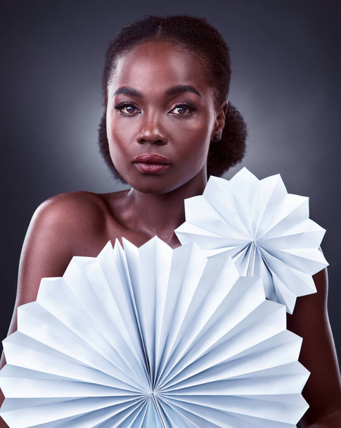 Theres no other like you, and thats your beauty. Studio portrait of a beautiful young woman posing with origami fans against a black background - Foto, Bild