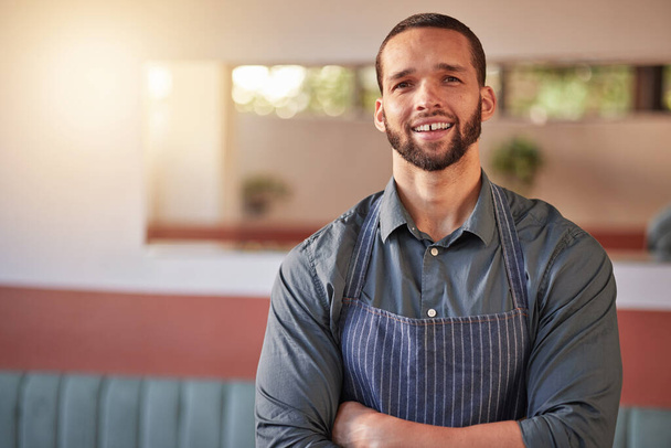 Restaurant, waiter portrait and man with arms crossed ready to take your order. Small business, server and confident, happy and proud young male employee from Brazil, worker or startup business owner. - Photo, Image