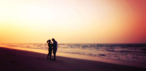 silhouet van paren knuffelen op het strand - Foto, afbeelding