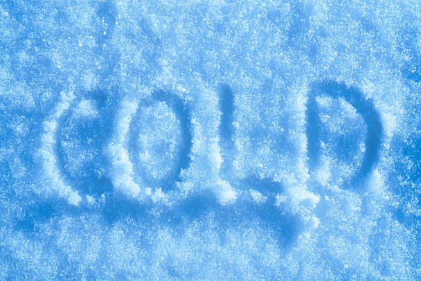 La palabra "frío" escrita en la nieve en tiempo soleado. Concepto de invierno y clima frío.        - Foto, imagen