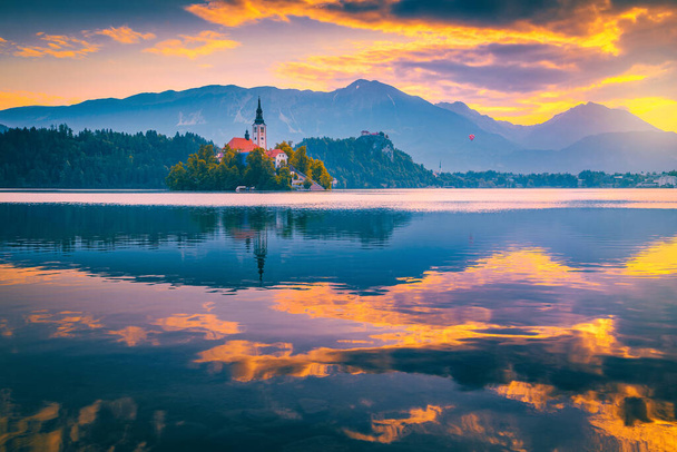 Stunning travel destination in Slovenia. Majestic sunrise with colorful clouds and hot air ballon over the lake Bled, Bled, Slovenia, Europe - Φωτογραφία, εικόνα