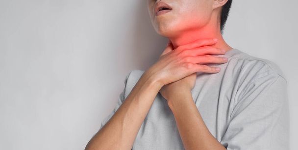 Tightness at the neck of Asian, Myanmar man. Concept of sore throat, pharyngitis, laryngitis, esophagitis, thyroiditis, dysphagia, choking or gasping. - Fotó, kép