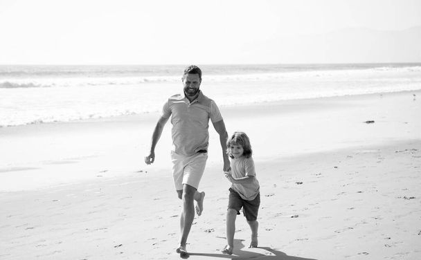szczęśliwy ojciec i syn biegając i bawiąc się na letniej plaży rodzinne wakacje, rodzina. - Zdjęcie, obraz