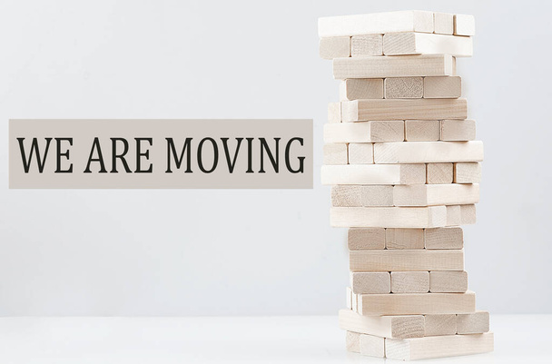 WE ARE MOVING text with wooden block stack on white background , business - Photo, Image