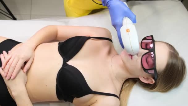 Laser removal of facial hair in women. A cosmetologist performs hardware laser hair removal on a patient in an aesthetic medicine clinic. - Séquence, vidéo