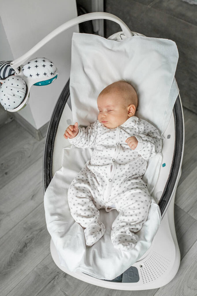 可愛い赤ん坊は部屋で赤ん坊の振動で眠る。新生児概念. - 写真・画像