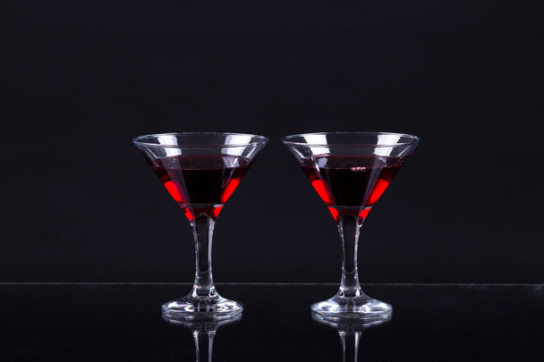 Red wine in a two glasses of martini on a black background - Foto, imagen