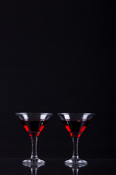 Czerwone wino w dwie szklanki Martini na czarnym tle - Zdjęcie, obraz