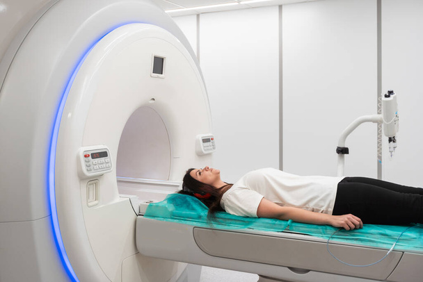 Medische CT of MRI Scan met een patiënt in het moderne ziekenhuislaboratorium. Interieur van radiografie afdeling. Technologisch geavanceerde apparatuur in witte kamer. Magnetische resonantie diagnostiek machine. - Foto, afbeelding