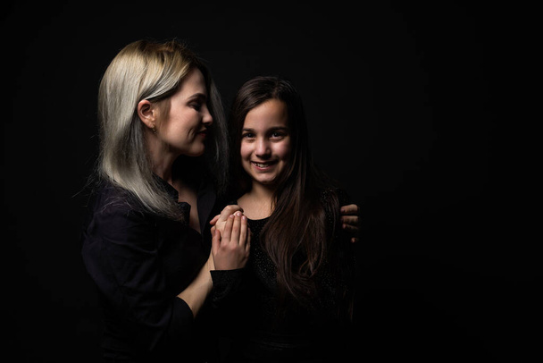 een klein meisje met haar moeder is bidden terwijl knuffelen. - Foto, afbeelding