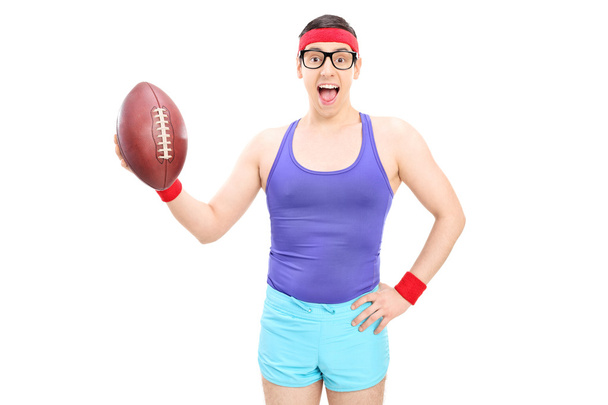 Excited nerdy guy holding football - Foto, afbeelding