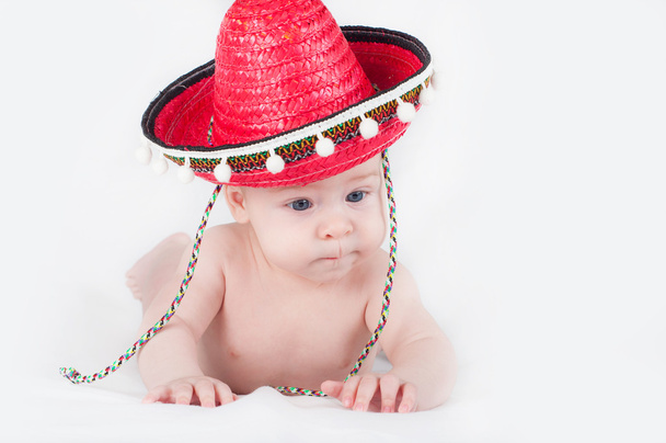 Cheerful little boy with a sombrero and maracas on a white background - Photo, Image