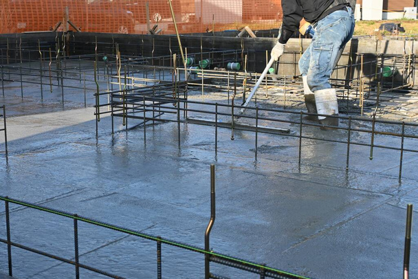 Вид на фундаментные работы строительной площадки жилого дома. Работы по размещению бетона. - Фото, изображение