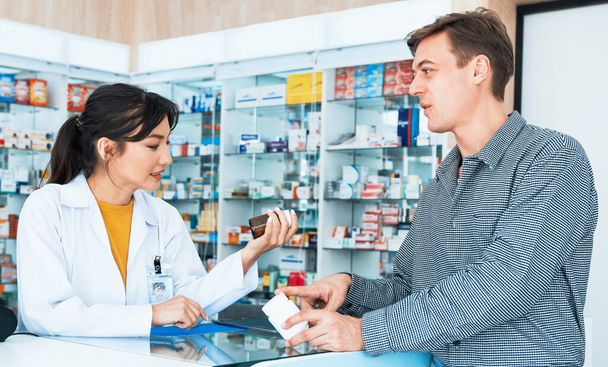 Professional pharmacist advise or explain property of qualified medical product to customer in pharmacy, druggist answer to client healthcare inquiry, medical service and consultation concept. - Foto, Imagen