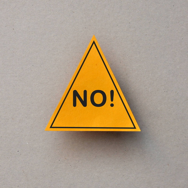 Слово "нет" в желтом треугольнике. Быть вдали от всего - Фото, изображение