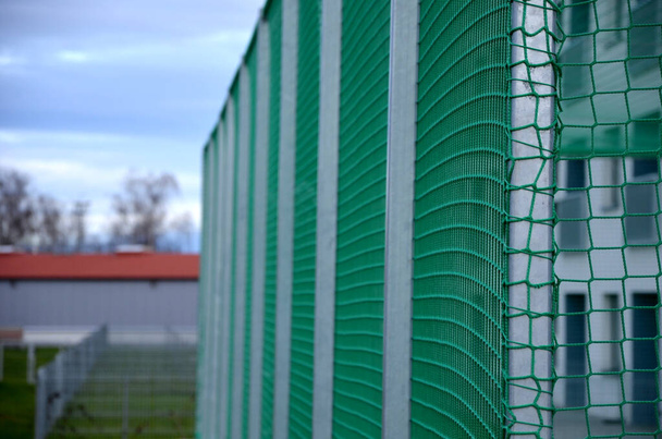 monitoiminen ulkona leikkipaikka pallopelejä koulussa. vihreä tekonurmi muovista matto linjat. Koripallokoreja ja jalkapallomaaleja. korkeiden verkkojen ja kaiteiden ympärillä  - Valokuva, kuva