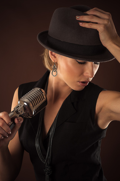 Woman in a hat with a retro microphone - Foto, immagini