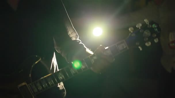 Músico tocando la guitarra en el club en una hermosa luz de fondo de colores. Primer plano
 - Metraje, vídeo