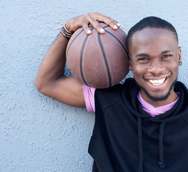 陽気なアフリカ系アメリカ人のバスケット ボールを保持しています。 - 写真・画像