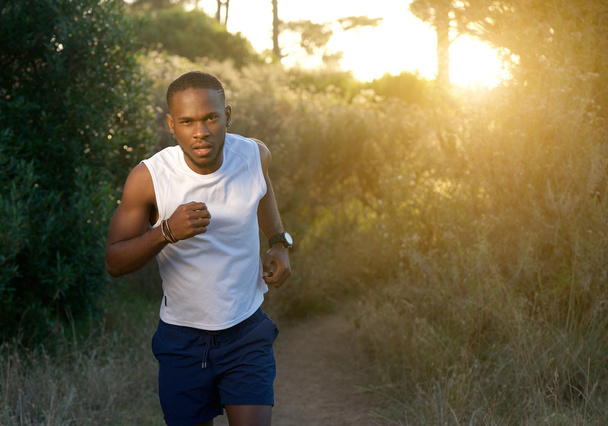 Nuori afrikkalainen amerikkalainen mies juoksee ulkona
 - Valokuva, kuva